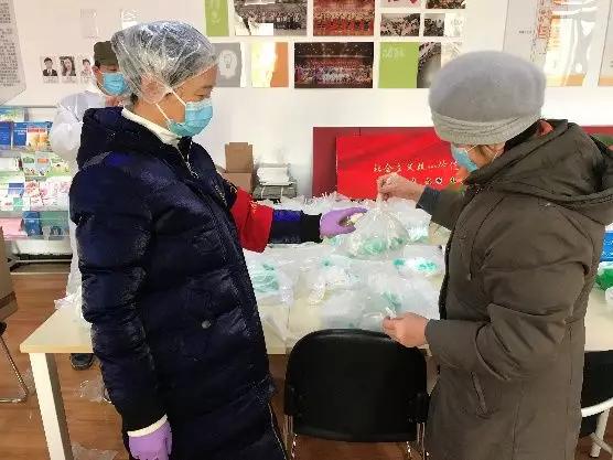 為樓棟分發(fā)口罩，并為包裝袋消毒